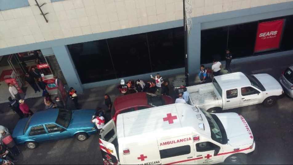 Mujer se quiso suicidar desde un edificio de Sears en Puebla; cayó sobre un hombre que iba pasando