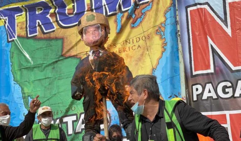 Activistas y migrantes mexicanos queman piñata de Trump y agentes migratorios en la frontera de Tijuana